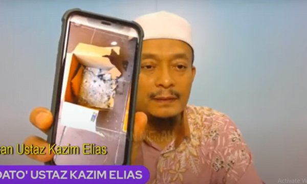Ustaz Kazim menunjukkan kotak abu yang mengandungi gambarnay yang terbakar