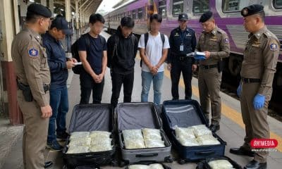 Police and investigators at a train platform inspecting three open suitcases filled with packaged items on a bench of the tracksignaled by officers looking down at the content.